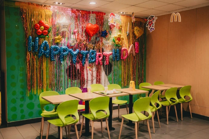 A room with a long table and green chairs